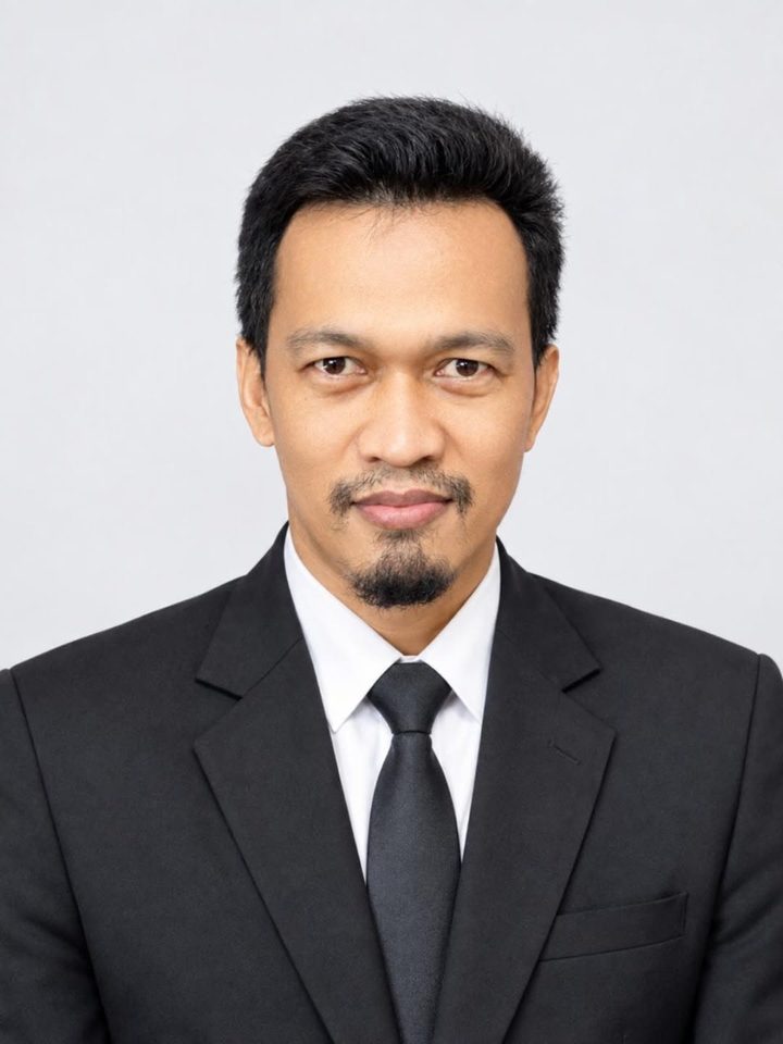 Portrait of Dadang Permana in a black suit and tie